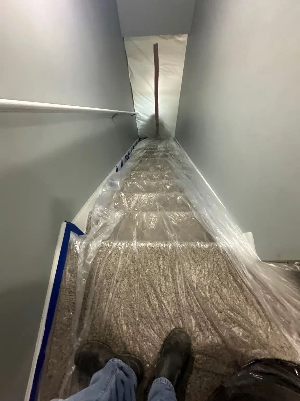 Protective sheeting run down the stairwell to keep the clean side of the townhome isolated