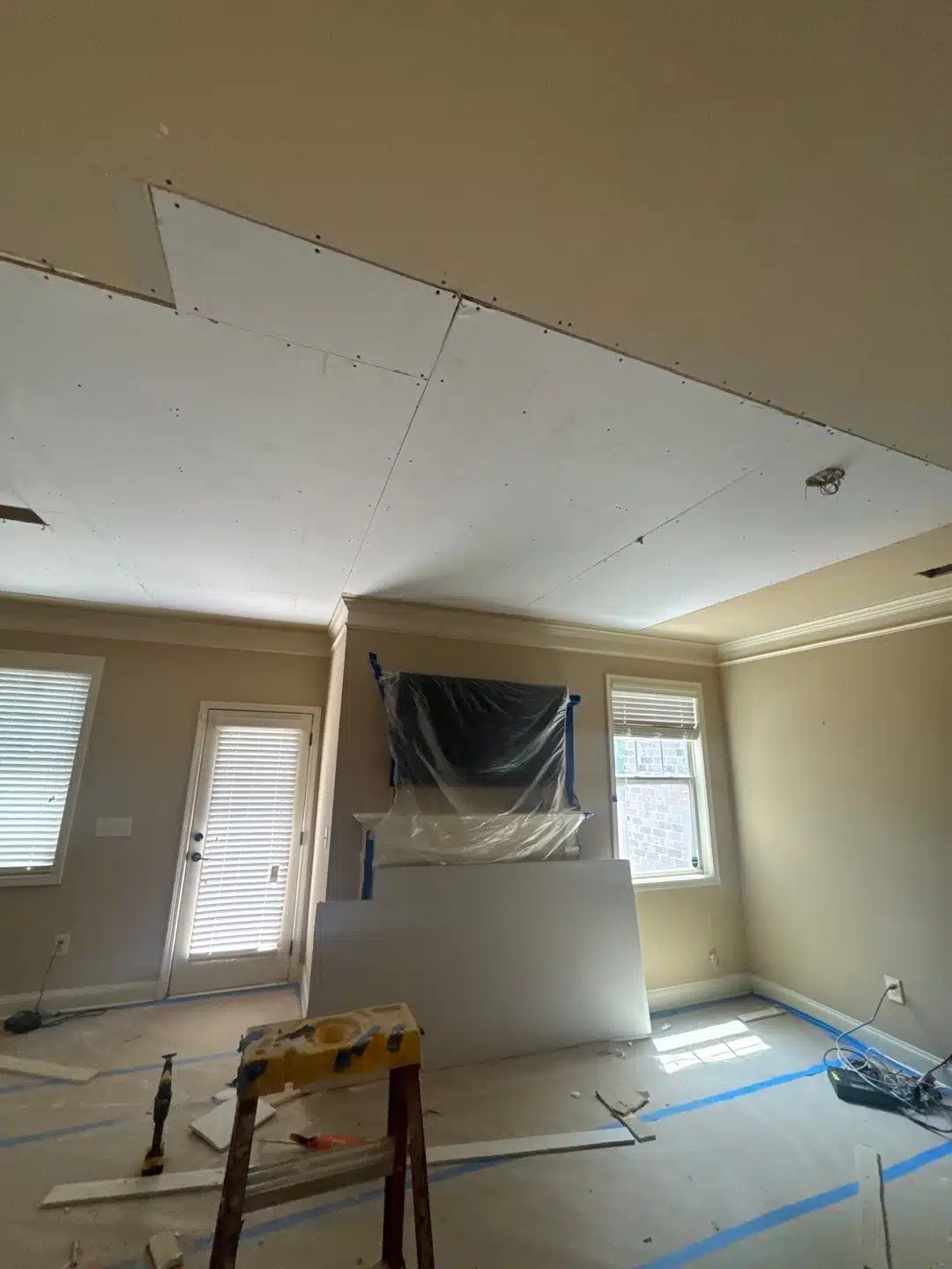 Water-damaged ceiling drywall removed along the wall line during controlled demolition