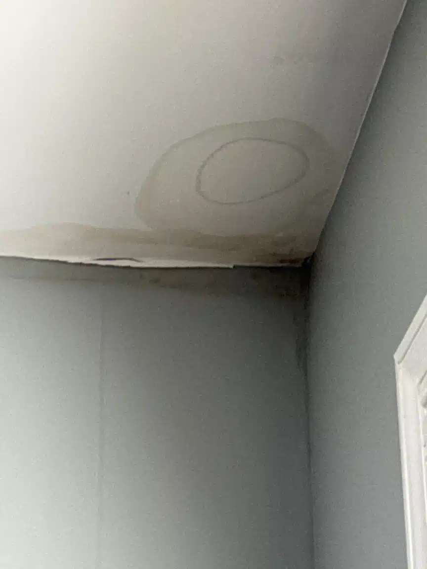 Staining across the closet ceiling and wall junction, marking where moisture had been sitting