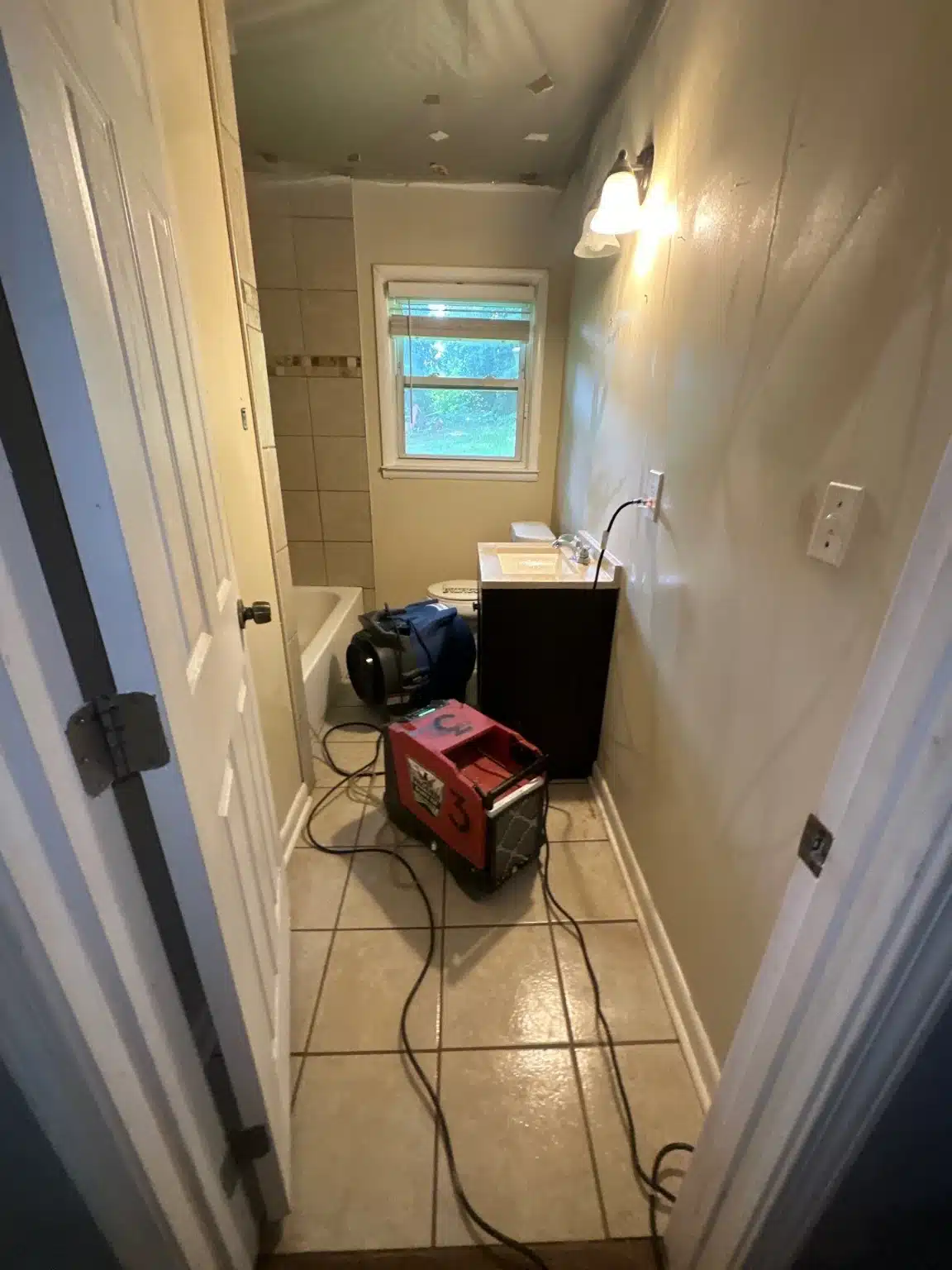 Drying equipment running in the bathroom during the structural drying phase