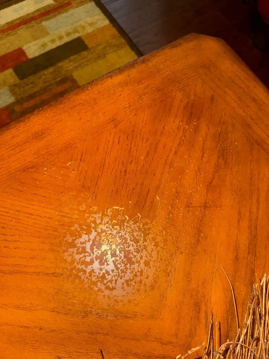 Water staining and finish damage on a wood surface below the leak
