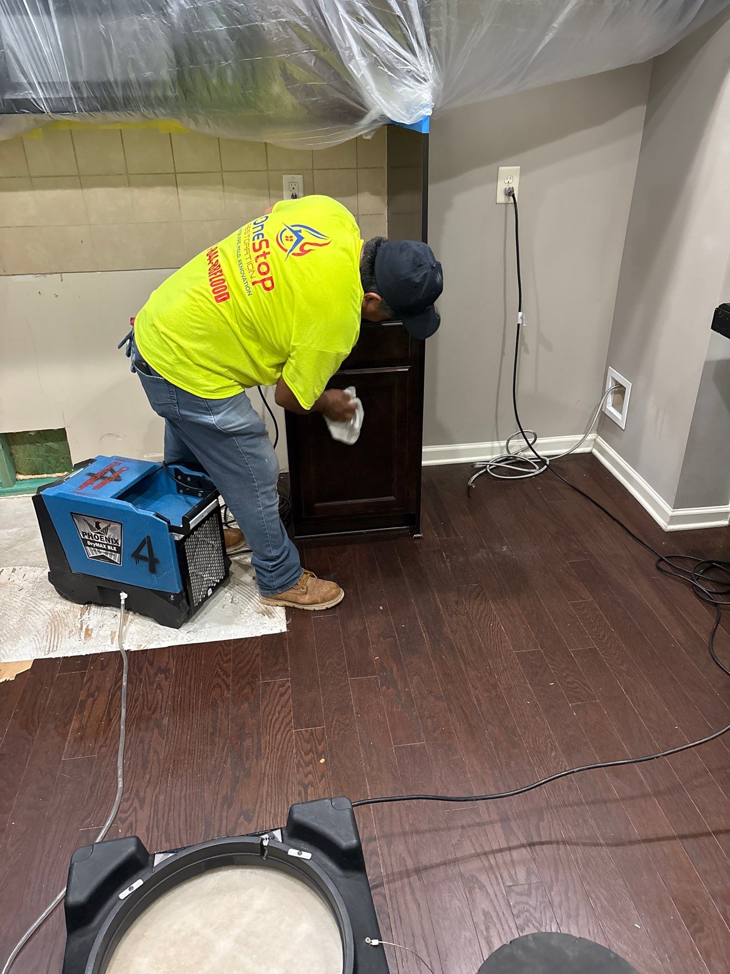 A technician running extraction equipment along a wall where water pushed under the baseboard