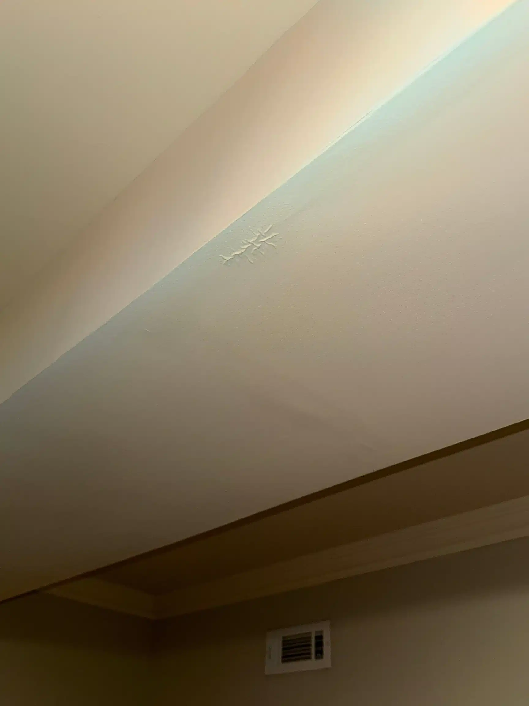 Staining spreading along the basement ceiling edge beside a wall vent