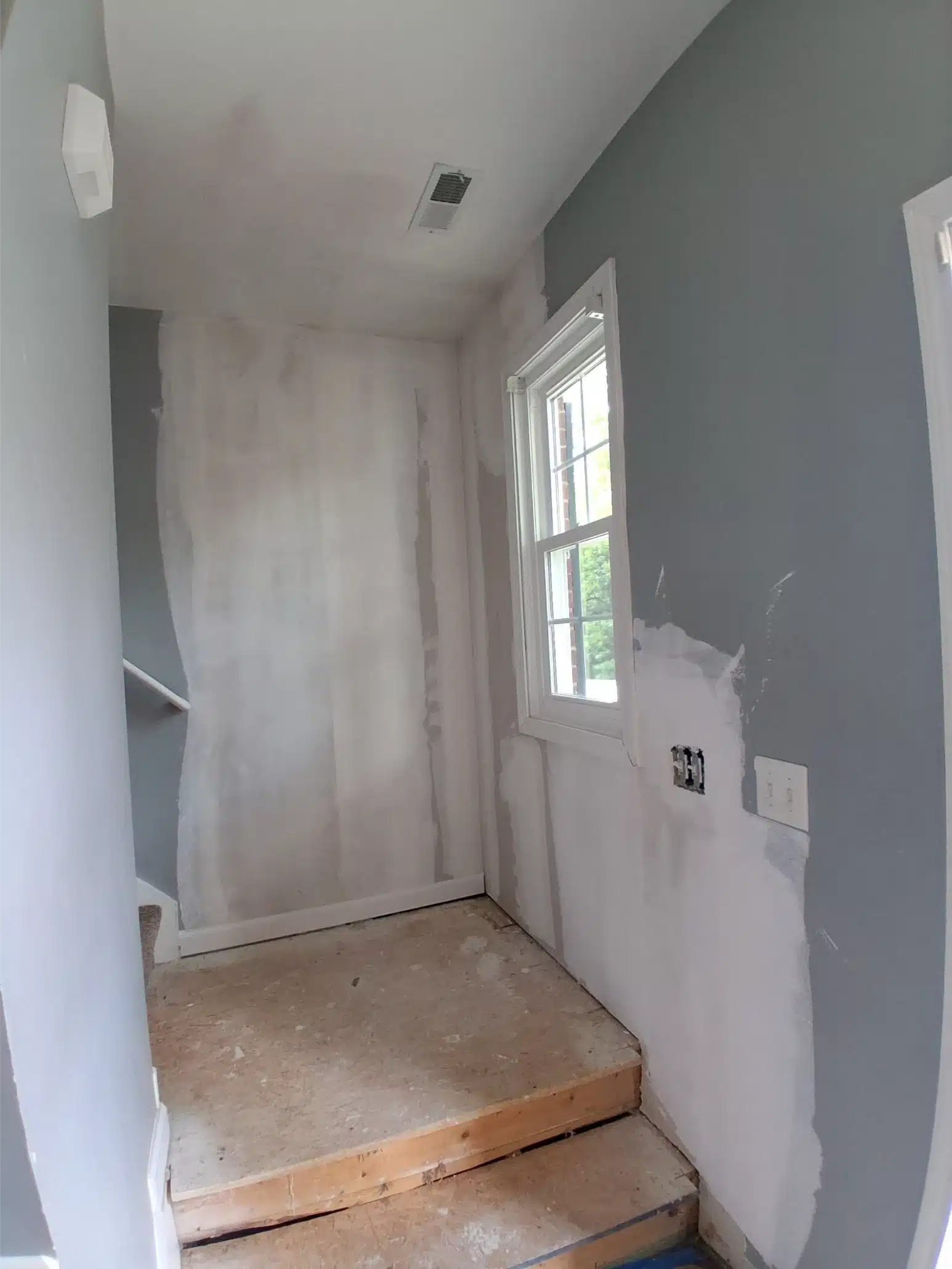 Landing and stairwell after reconstruction, with new drywall and finishes in place
