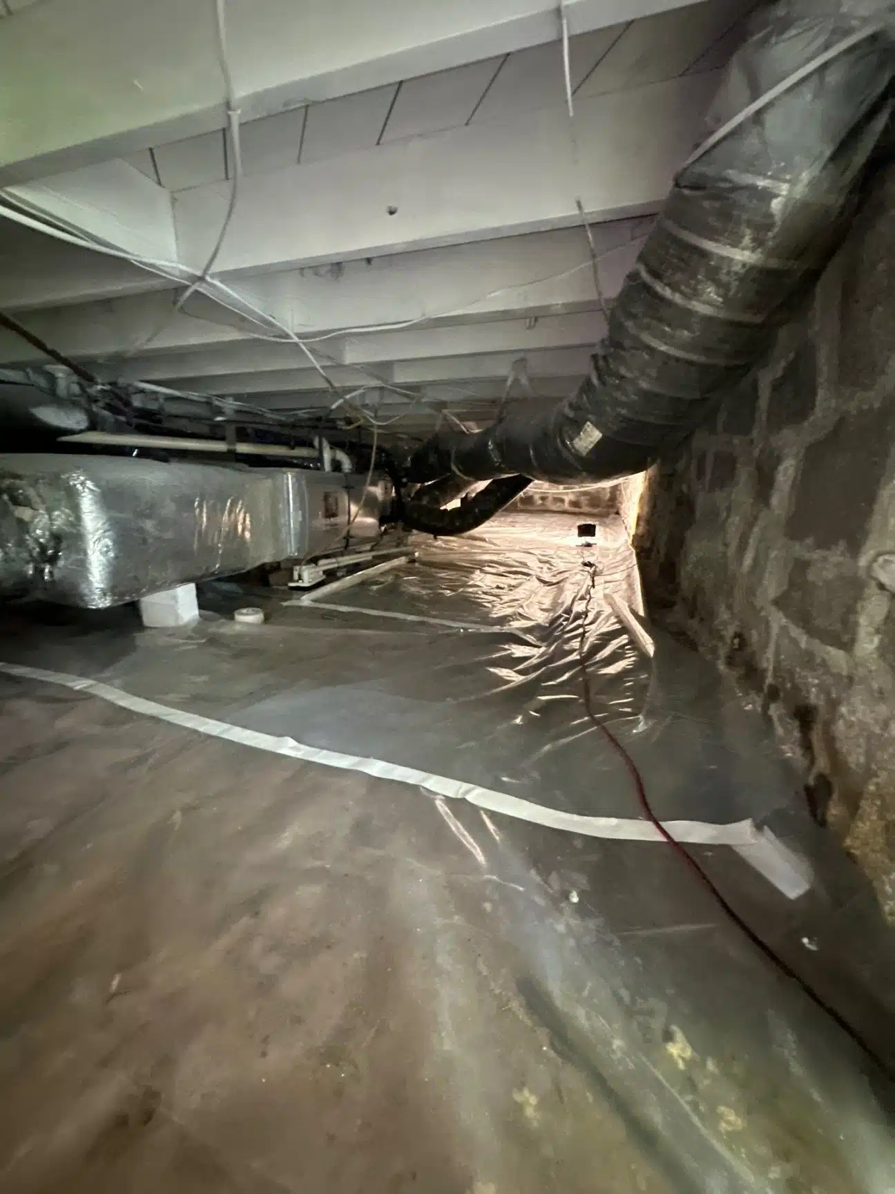 Decatur crawlspace with a bare dirt floor, exposed ductwork and damp foundation walls