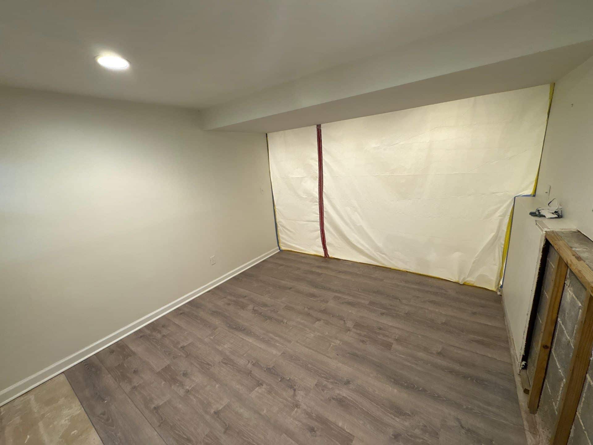 A residential room sealed with plastic containment sheeting on a One Stop Restoration job site