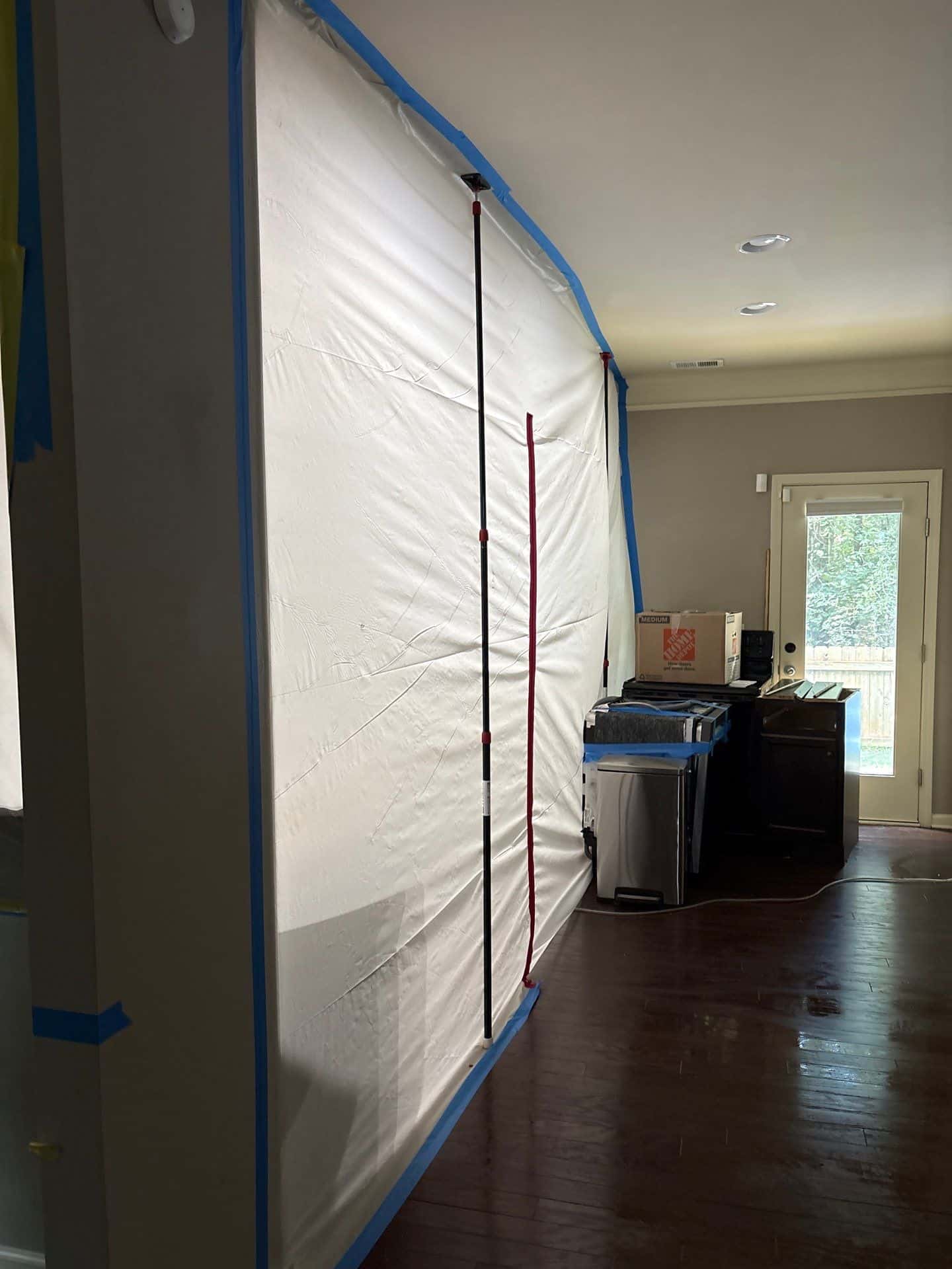 A sealed drying enclosure set up inside a residential room after water extraction