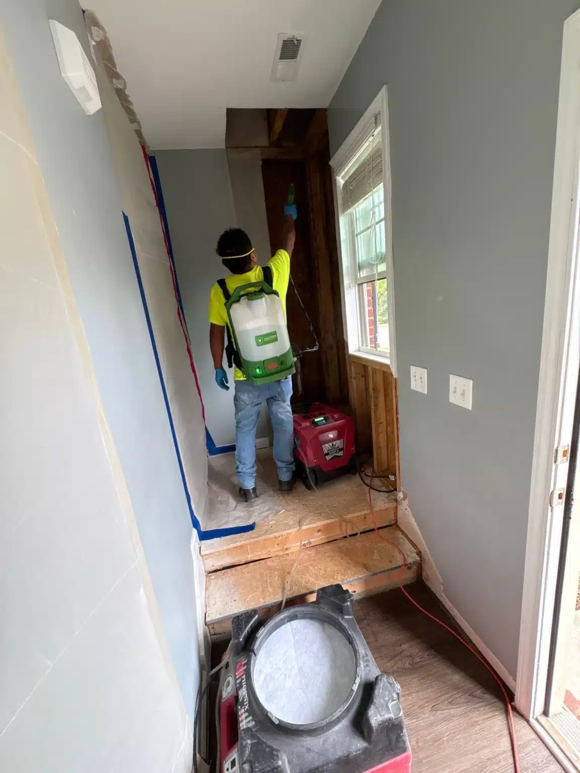 Technician working the landing with the affected framing exposed and equipment running