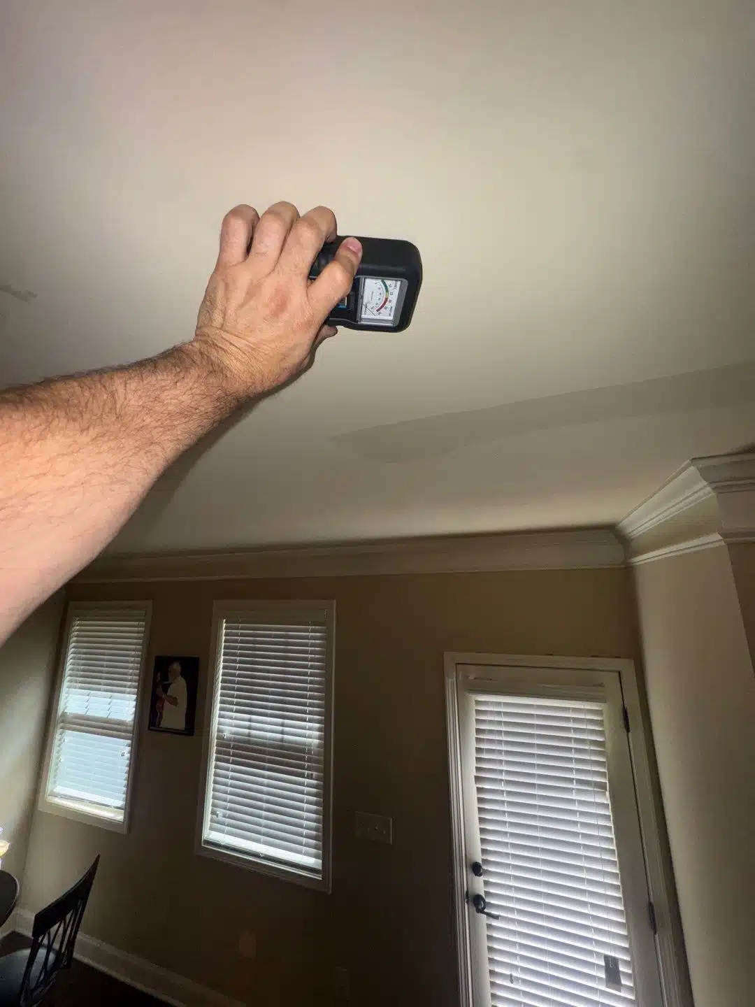 Technician scanning the ceiling with an infrared camera to map the water migration path