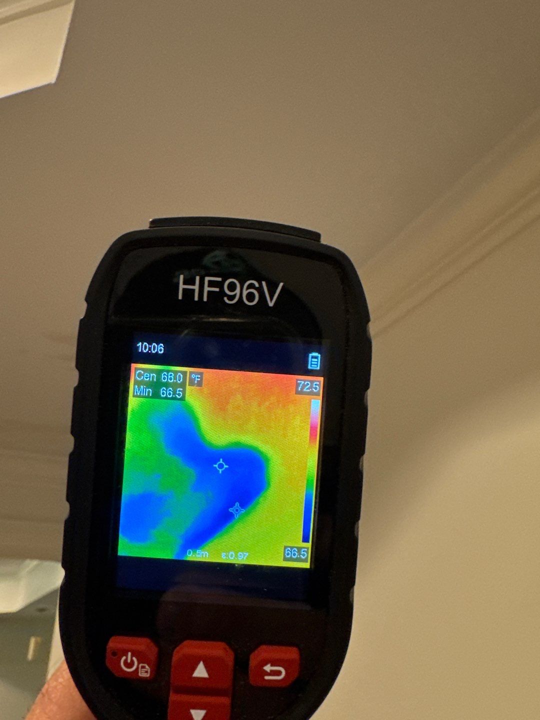 An infrared thermal imaging camera showing a heat map of hidden moisture inside a wall