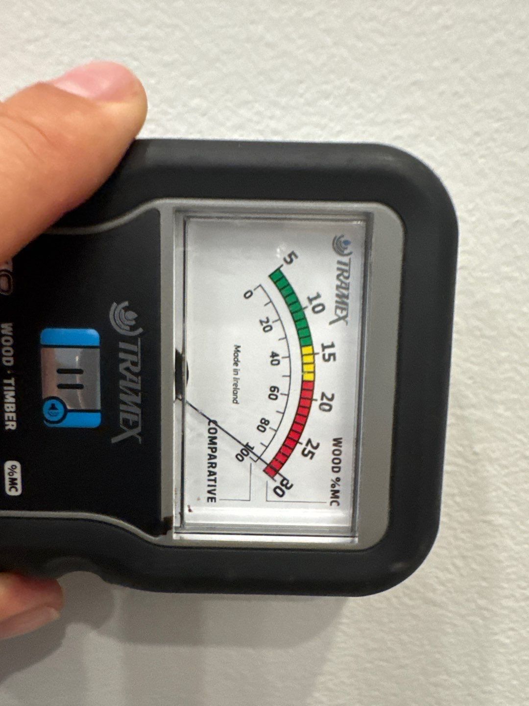 A moisture meter reading taken on site, the needle showing the material is still wet