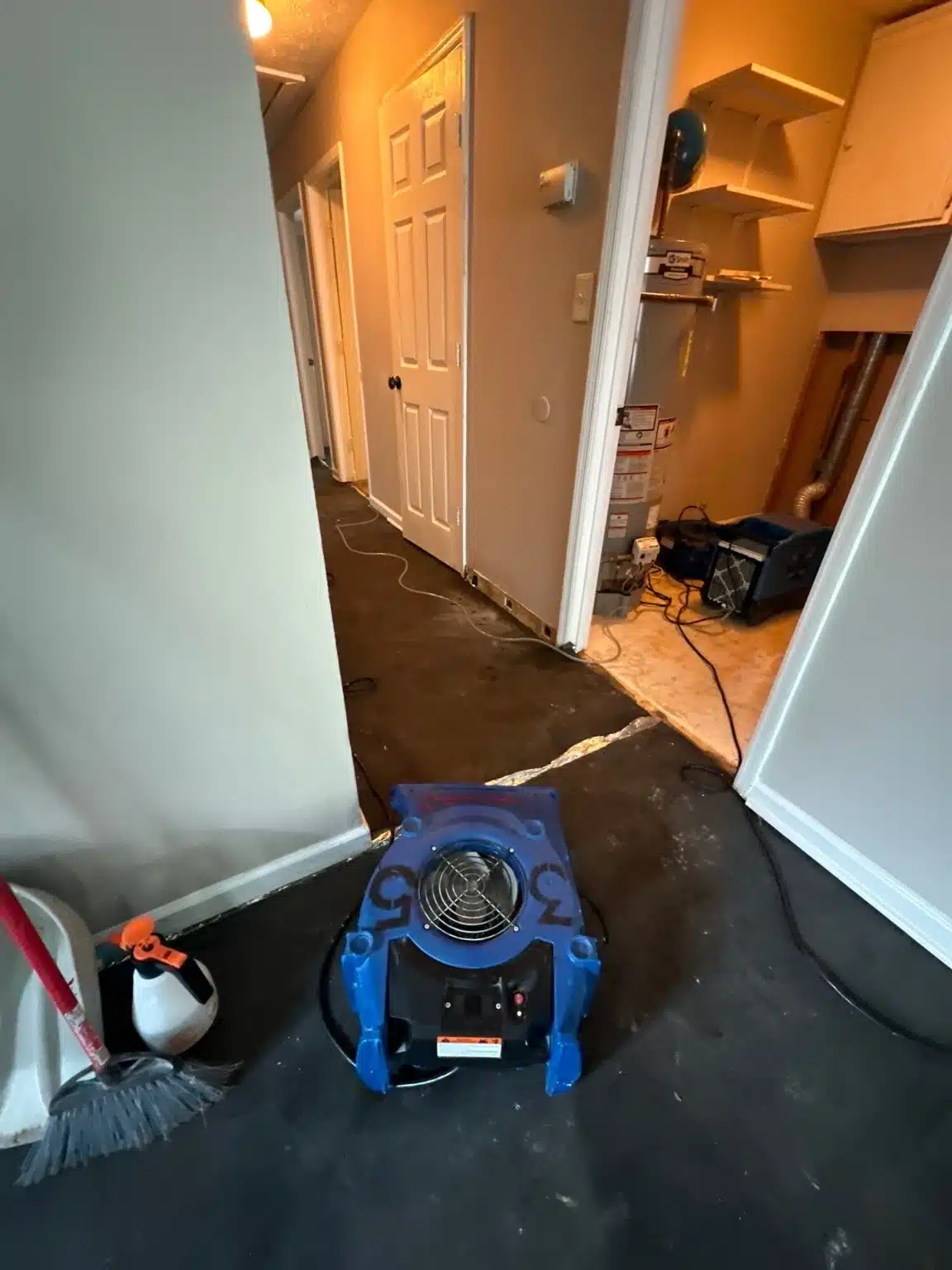 Air mover running in the hallway where water had spread out from under the laundry closet door