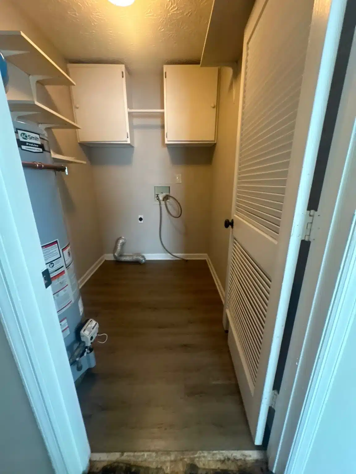 Laundry closet cleared and dried, with the affected flooring removed back to the subfloor
