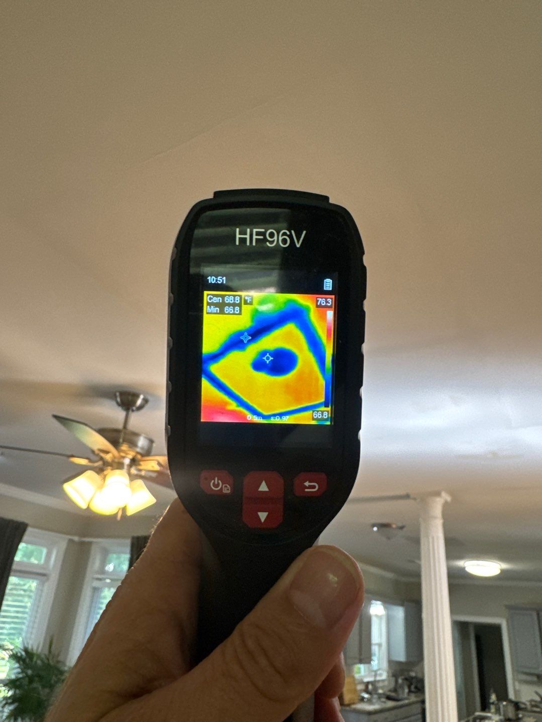 A thermal imaging camera screen showing the temperature signature of moisture hidden inside a wall